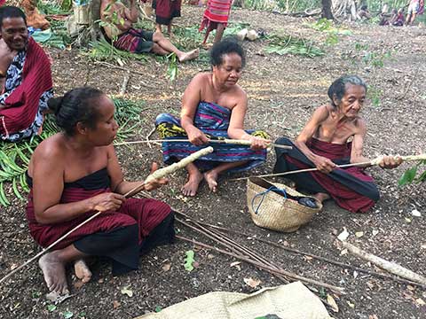 Женщины в Восточном Тиморе готовят палочки для подсвечников, чтобы осветить местный фестиваль